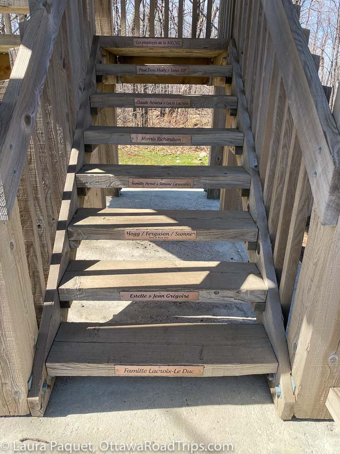 shallow open wooden stairs in the wooden observation tower at mont morissette, with names of donors on plaques on the risers