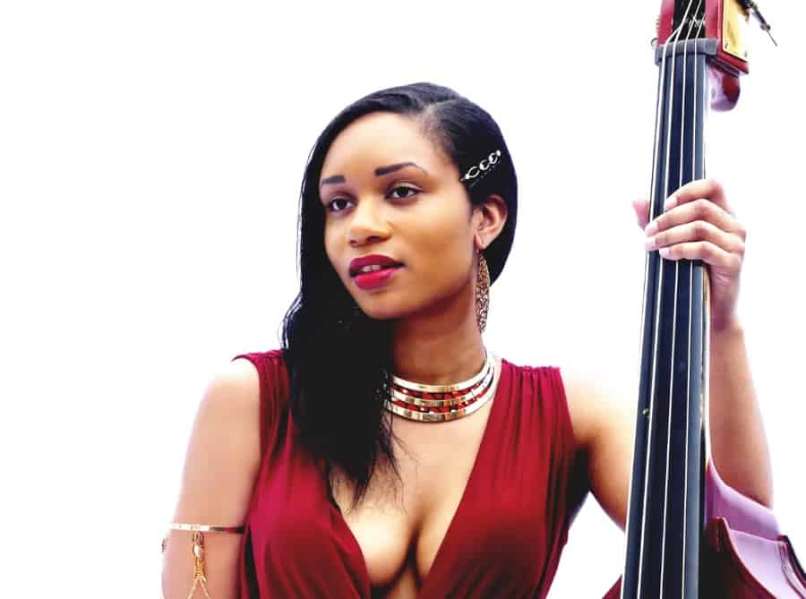 woman in a formal red dress holding the neck of a double bass