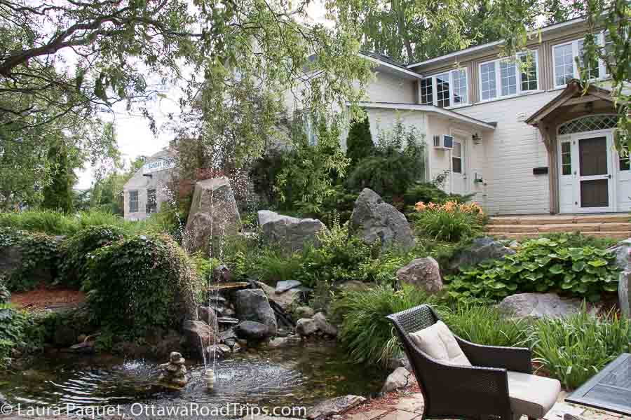 rock garden with a water feature and wicker chairs