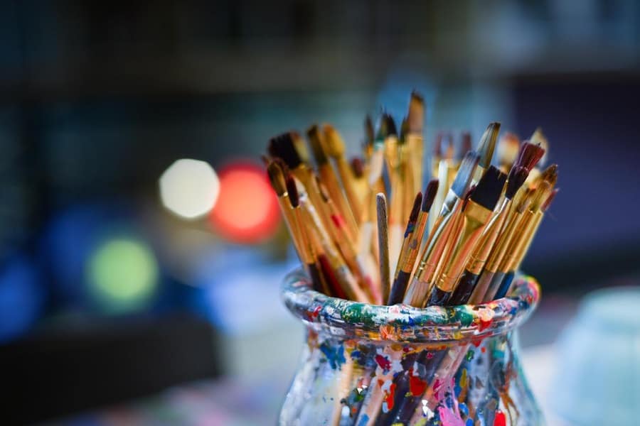 jar of artists' brushes against blurred background