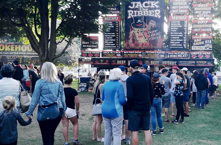 People lined up in front of a ribber's stand at the Brockville Ribfest.