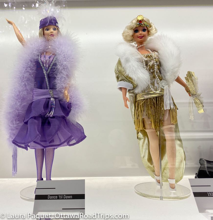 barbies in purple and gold flapper dresses with feather boas