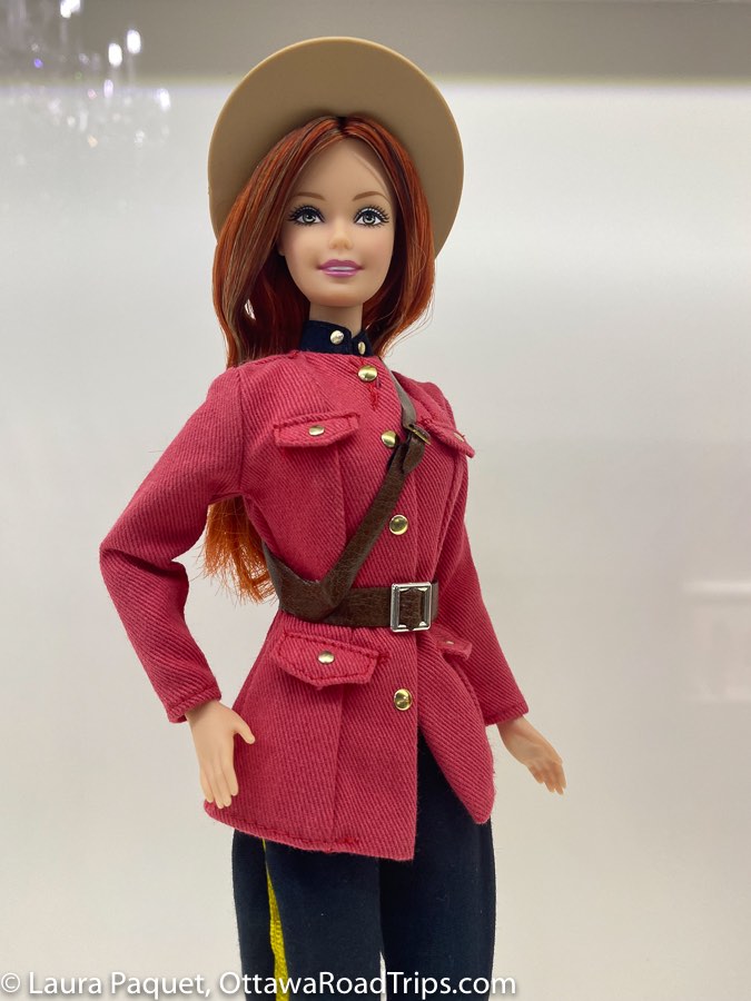 barbie with long red hair, wearing a red rcmp dress uniform