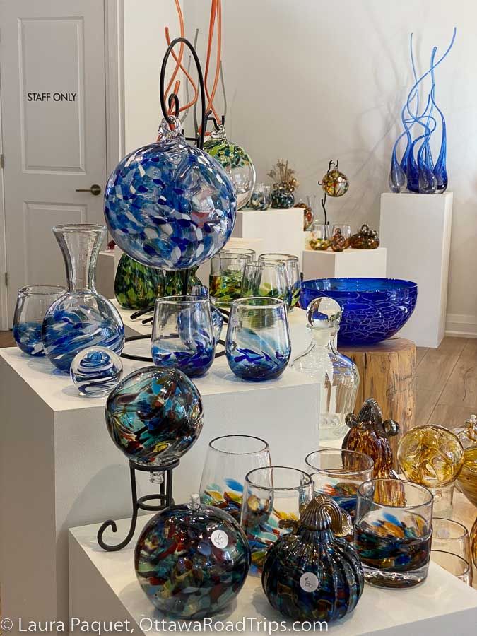 A display of blue and yellow tumblers, witch balls, decanters and bowls at Gray Art Glass in Merrickville.