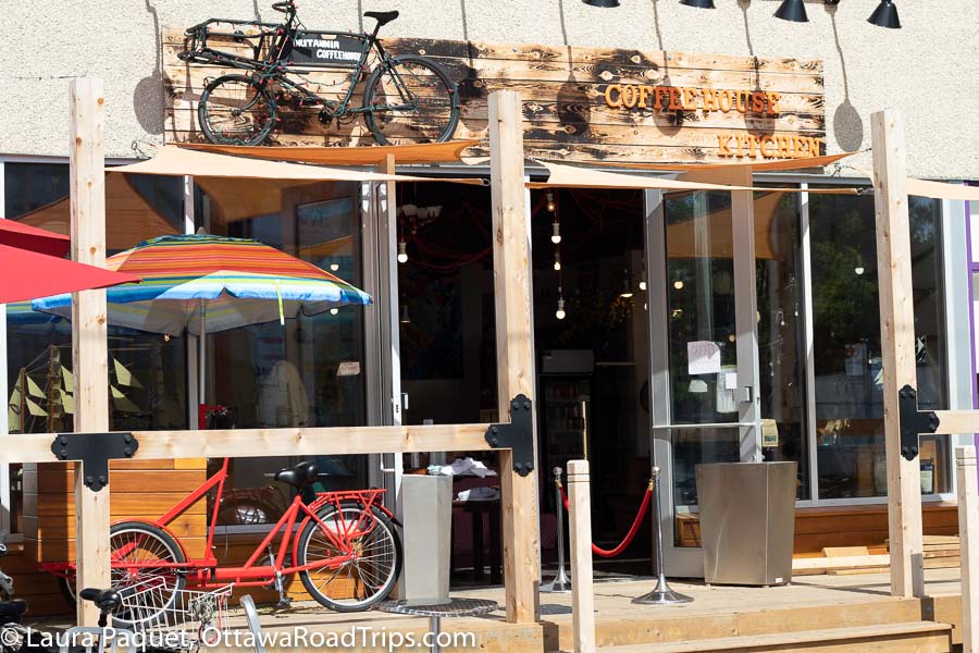 wooden coffee house patio with bicycle frames on patio and sign