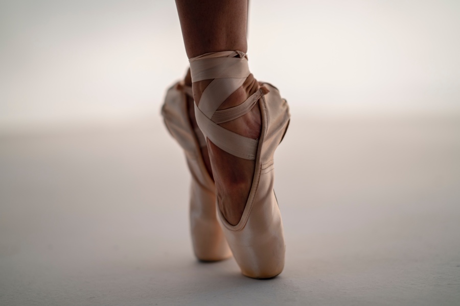 closeup of feet in pink ballet slippers on point