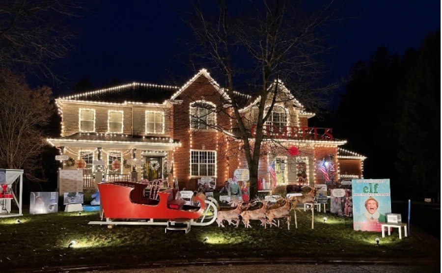 ottawa christmas lights include a modern brick house illuminated with lights and with large cutouts from the movie elf on lawn.
