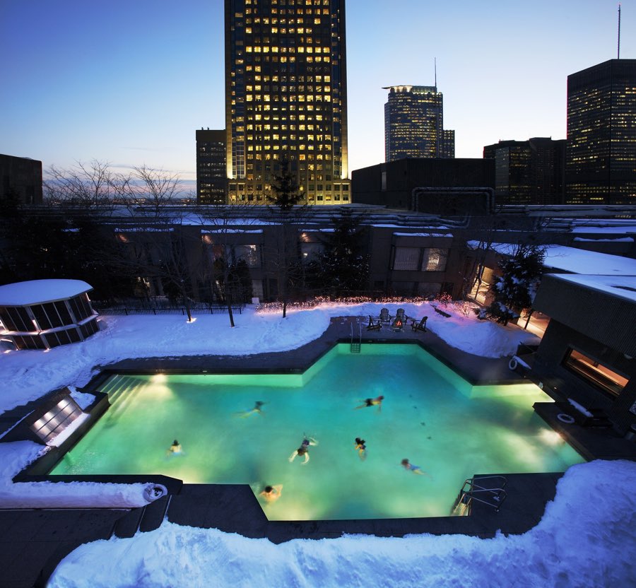 illuminated rooftop pool at the hotel bonaventure montreal in winter at dusk, surrounded by tall buildings