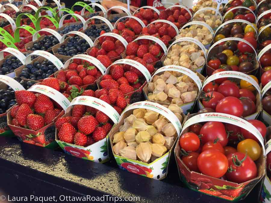 baskets of strawberries, tomatoes and other produce at the marché jean-talon market in montreal