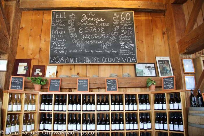 shelves of wine and chalkboard at grange winery in prince edward county