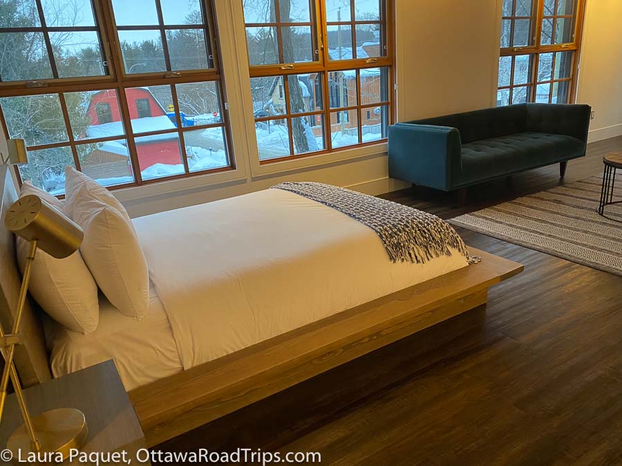 platform bed, with large windows overlooking village in winter in background