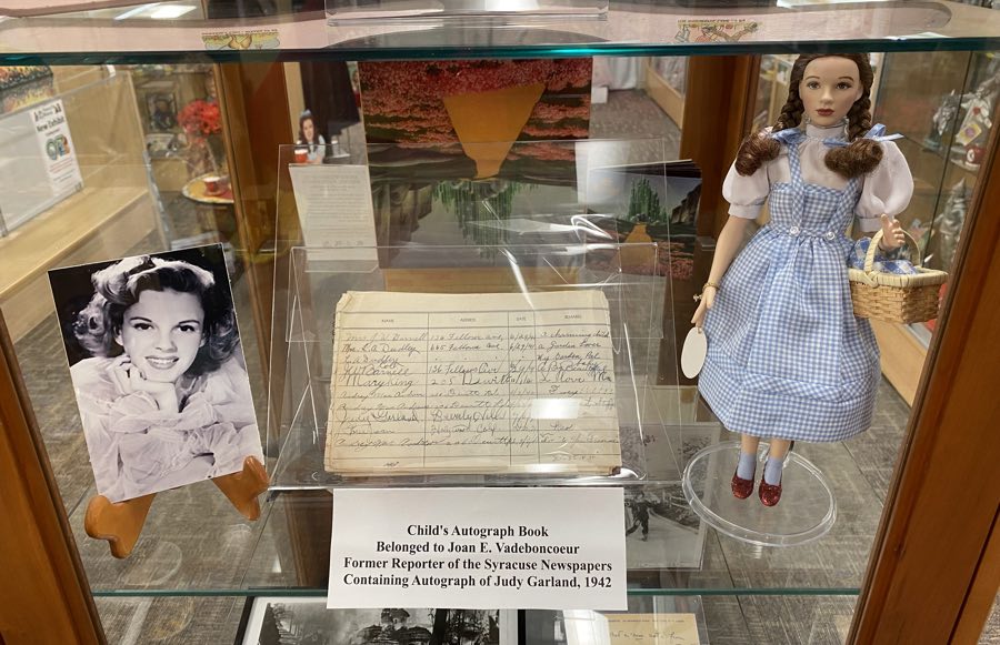 display case with dorothy wizard of oz doll and judy garland autograph