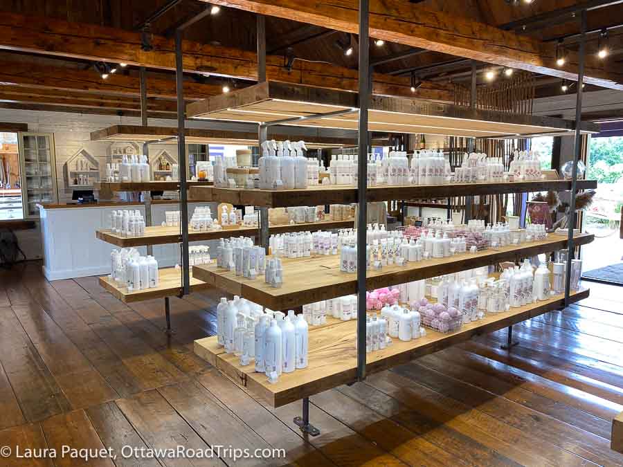 wood and metal shelves stocked with white bottles and packages in a shop with wood floors