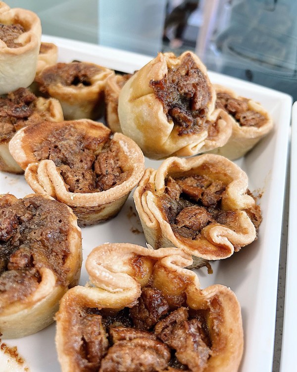 White tray of butter tarts with pecans at Tasty Goodness Bake Shop in Westport, Ontario.