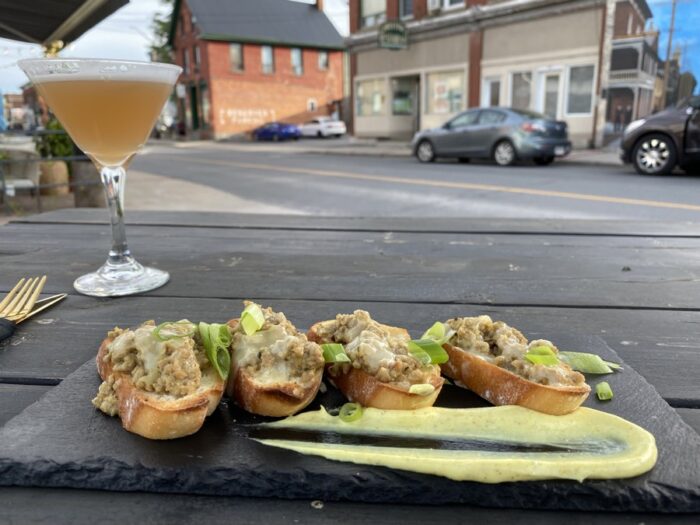crostini on a plate with a cocktail in the background