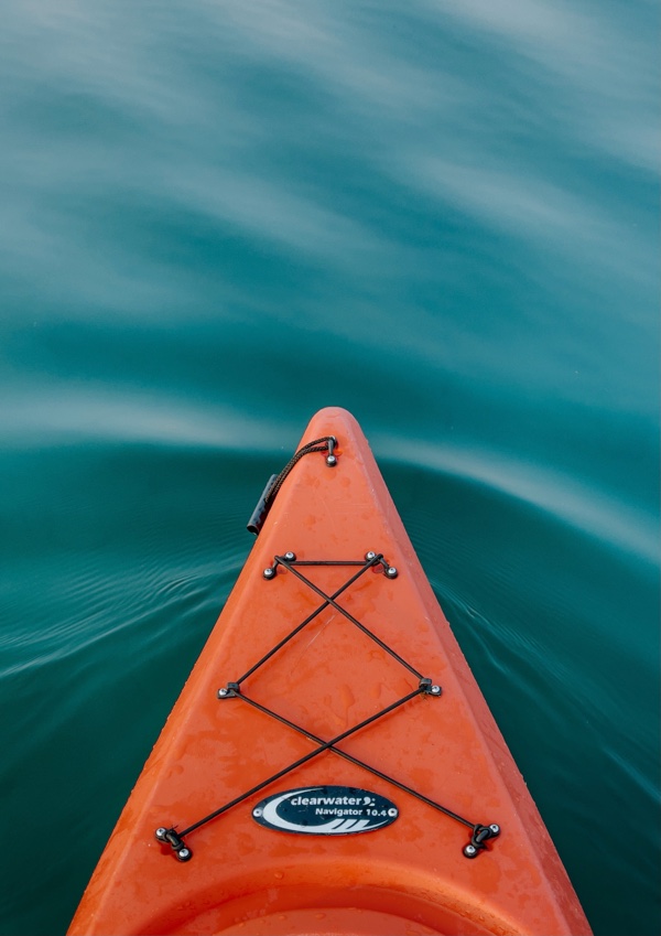 bow of an orange kayak against the water