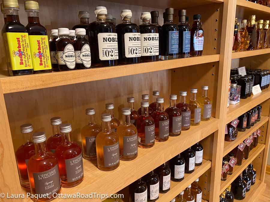 bottles of maple syrup on wooden shelves in maple run emporium in potsdam, new york.