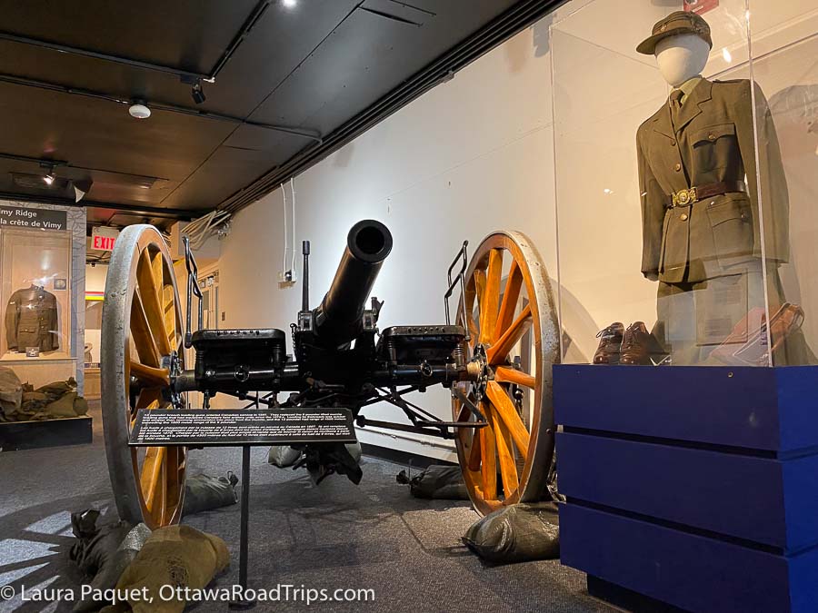 uniforms and a vintage artillery piece in a petawawa museum