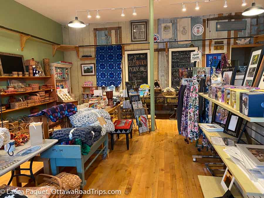baskets, quilts and other items on wooden shelves in pickens hall and general store in heuvelton, new york.
