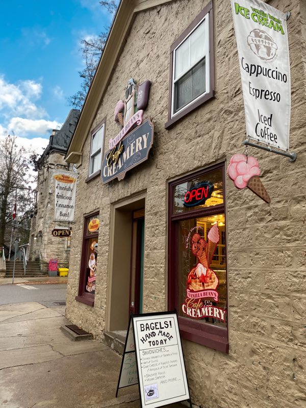 stone building with old-style sign and signs advertising ice cream cones and waffles