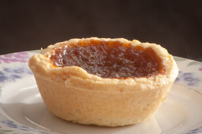 close up of a butter tart on a white flowered plate