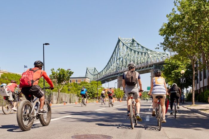 go bike montreal cover en credit © maxime juneau_apmj 1 - Ottawa Road Trips people cycling below green bridge in montreal