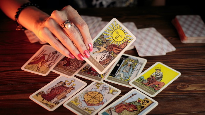 woman's hand turning over tarot cards