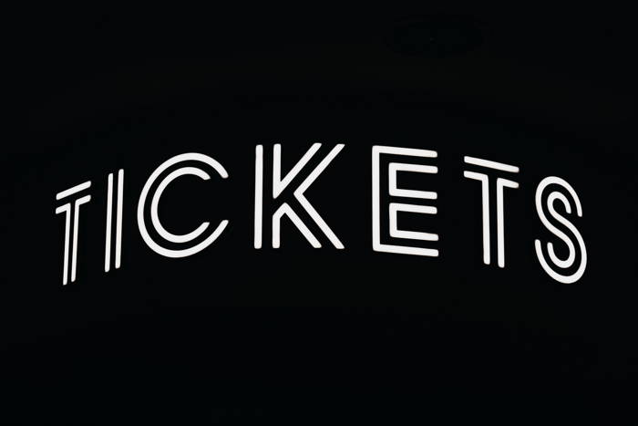 black-and-white graphic reading "tickets"