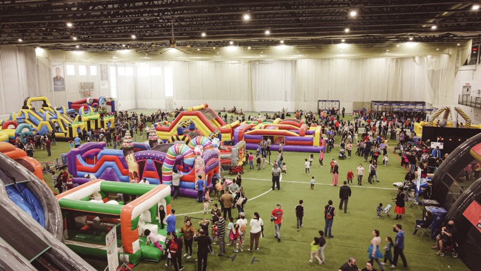 people amid bouncy castles and inflatables in a large arena