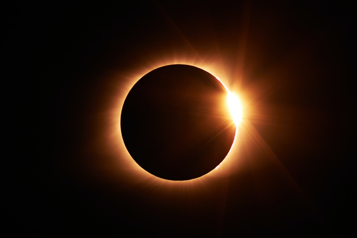 total solar eclipse showing black sky and black moon with orange solar corona to illustrate post about 2024 solar eclipse