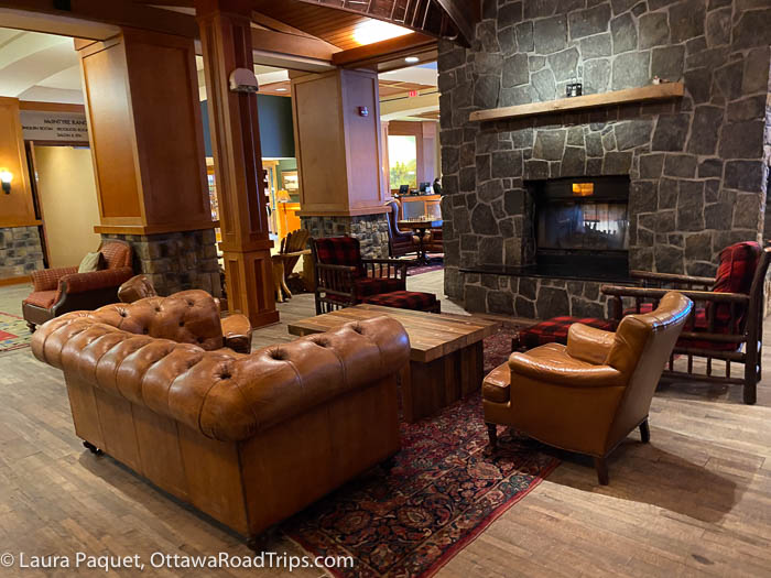 lobby with large stone fireplace and brown leather couches and chairs