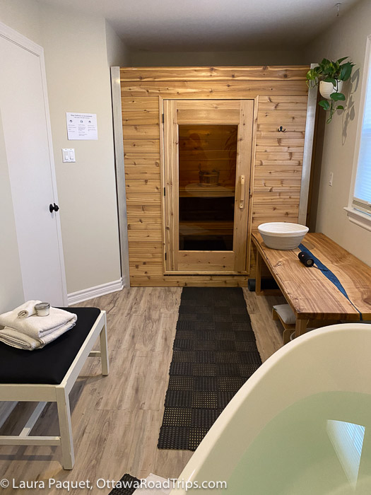 room with small sauna. wooden bench and soaker tub