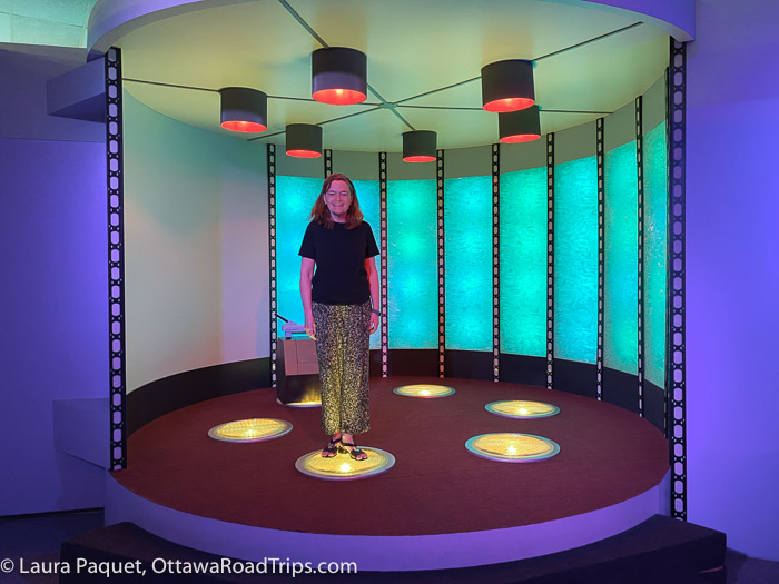 woman standing on one of six lighted circles in a replica star trek transporter room