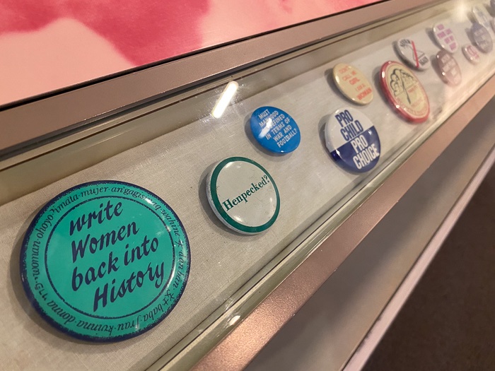 feminist buttons in a glass case at the Women's Rights National Historical Park in Seneca Falls, New York