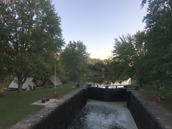 two otentiks (beige canvas tents with wooden floors) next to a rideau canal lock.