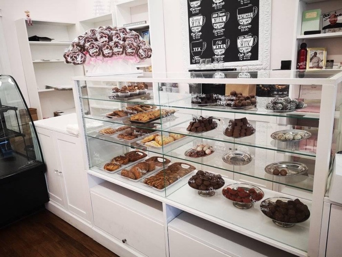 a glass display case filled with pastries in a bakery