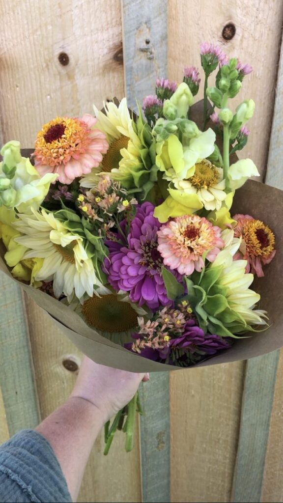 a bouquet of various flowers in a paper cone