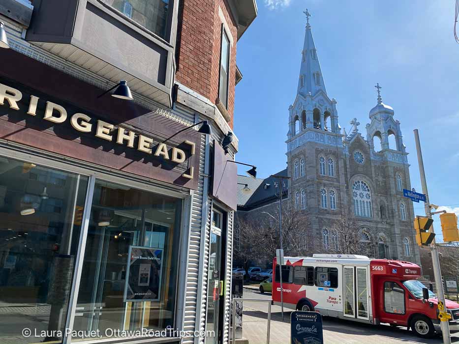 hintonburg bridgehead - Ottawa Road Trips coffee shop window with para transpo bus and large church in background in hintonburg