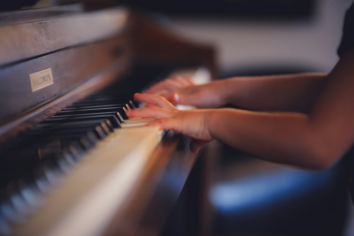 closeup of hand on the keyboard of a piano