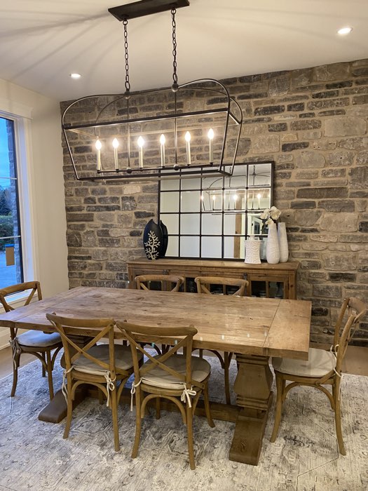 dining room with stone wall and large wooden table