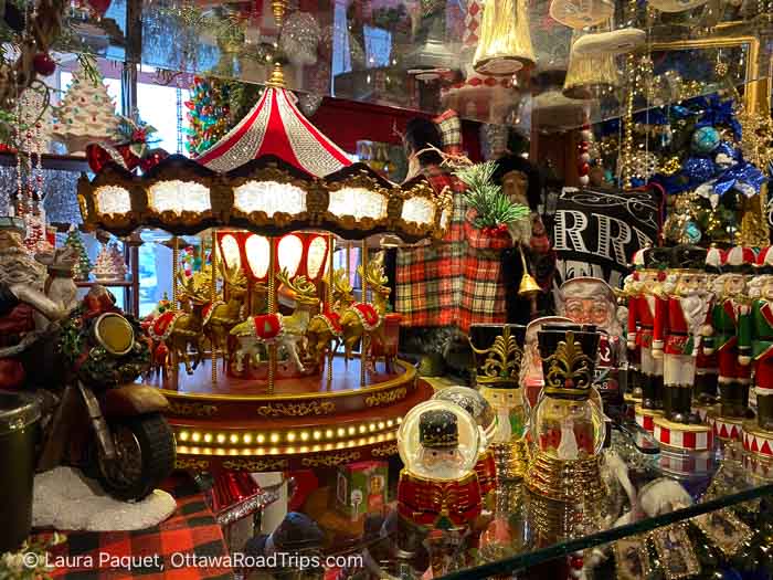 shelf with carousel and nutcracker ornaments and christmas snow globes