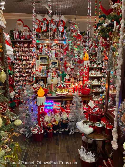 store wall covered with christmas ornaments, statues, garland, stockings and lights at tinseltown christmas emporium.