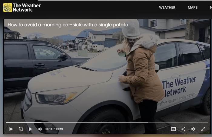 screen capture of a woman in a parka rubbing a cut potato over the windshield of a weather network car