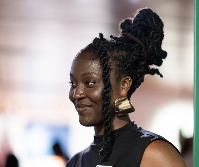 young black woman with large gold earrings, smiling and in profile