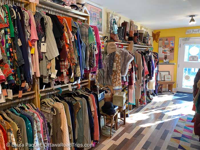 interior of vintage clothing shop with racks of clothes, shelves of boots