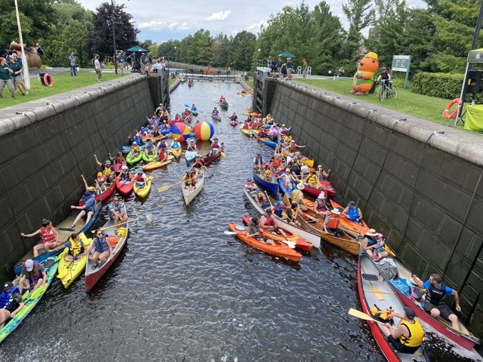 about two dozen brightly coloured kayaks and canoes in the hartwell locks on the rideau canal