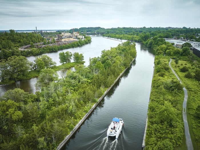 10144_rto9-trent-severnwaterways_june2024_retouched_imgdji_0215-medium - Ottawa Road Trips aerial shot of a pontoon boat going through a canal surrounded by trees
