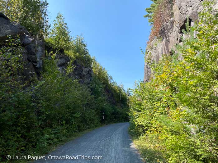 crushed stone trail on le p'tit Train du Nord with rock faces on either side