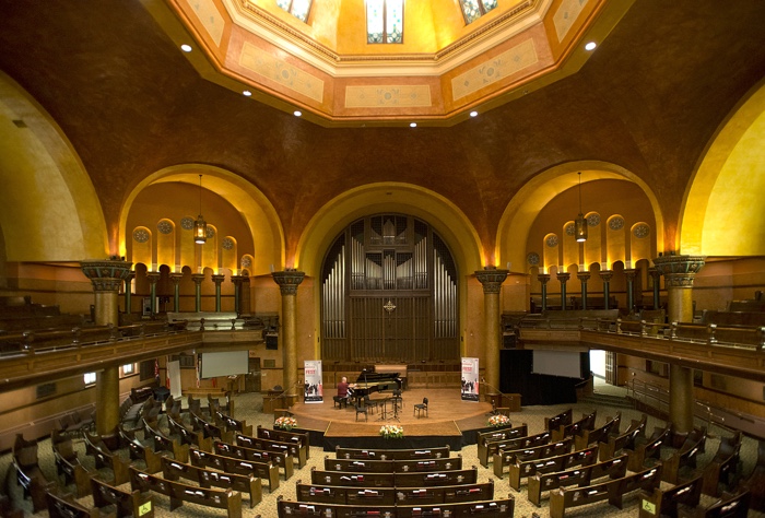 interior of large domed church with stained-glass windows in dome and large pipe organ below