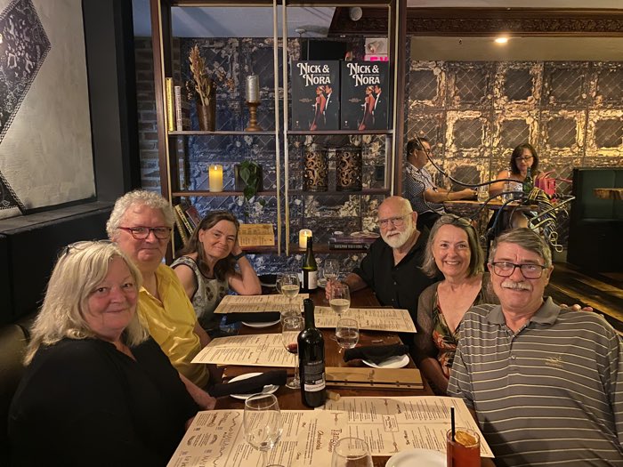 six people sitting around a wooden table with large menus at kingston restaurant tango nuevo